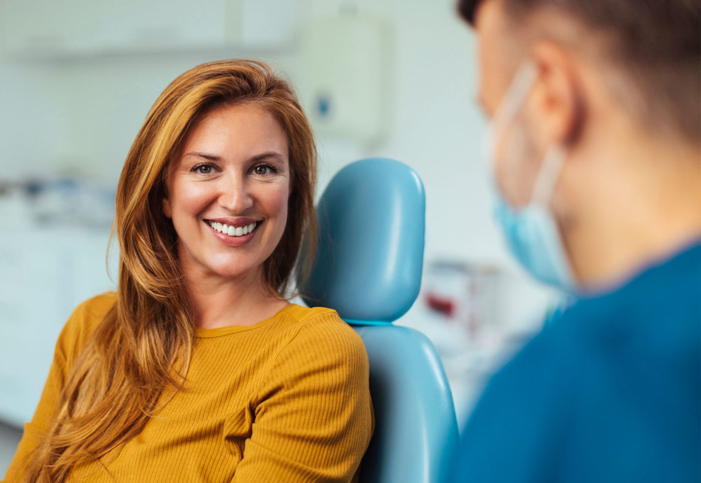 A woman happily in the exam chair for dental X-rays in San Diego.